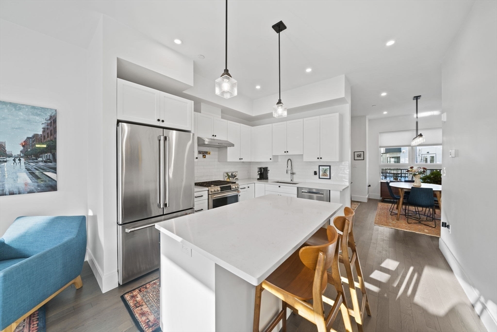 17-31 Charles Park Road, Unit 196 Boston, MA 02132 - Photo 4 of 25 a kitchen with stainless steel appliances kitchen island a refrigerator and a view of living room