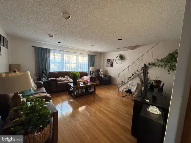 a living room with furniture floor to ceiling window and a wooden floor