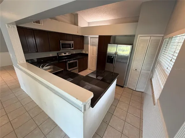 a kitchen with stainless steel appliances granite countertop a refrigerator and a stove