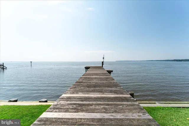 an aerial view of a house with a garden and lake view