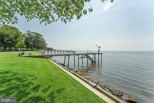 an empty room with chandelier fan and windows