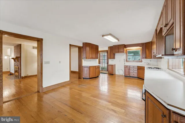 a large kitchen with stainless steel appliances granite countertop a stove a sink dishwasher and microwave with wooden floor