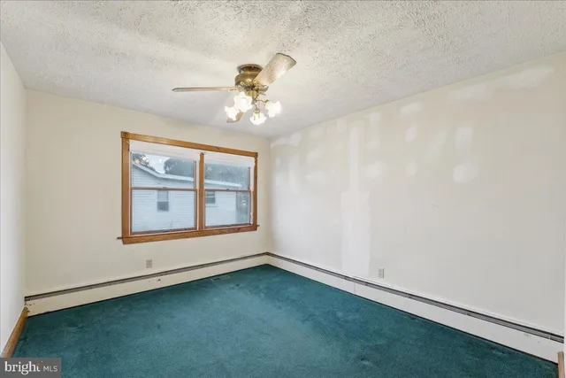 a view of a room with a ceiling fan and a window
