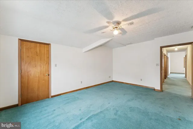 an empty room with a window and a ceiling fan