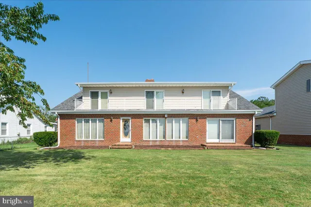 a view of a house with a big yard and large trees