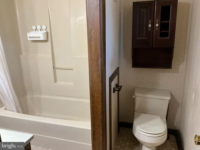 a white toilet sitting next to a bath tub