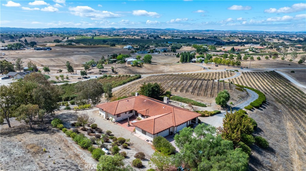 an aerial view of a house with a garden and lake view