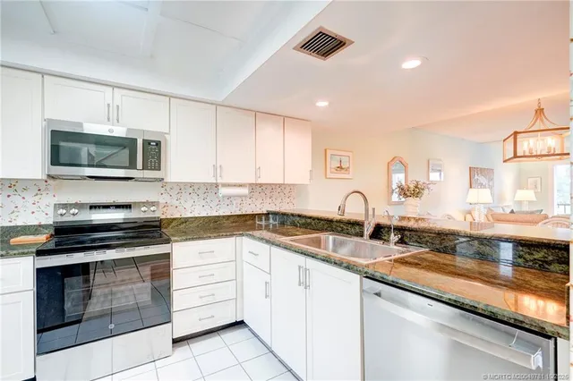 a kitchen with stainless steel appliances a stove a microwave sink and cabinets
