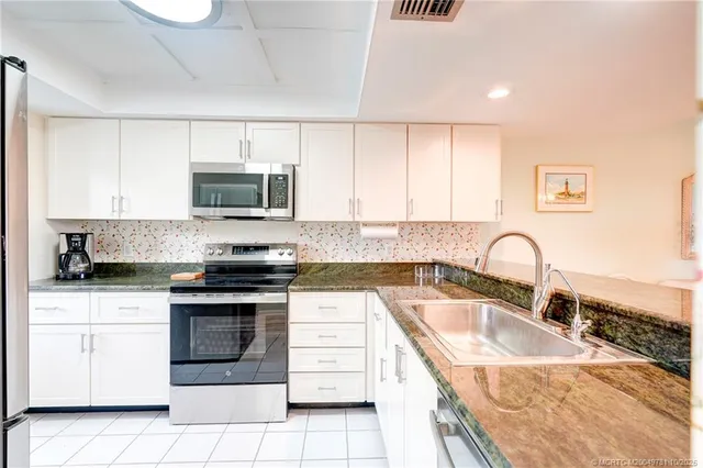 a kitchen with stainless steel appliances granite countertop a sink and a granite counter tops with a large window