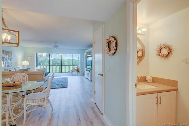 a dining room with furniture a chandelier and wooden floor