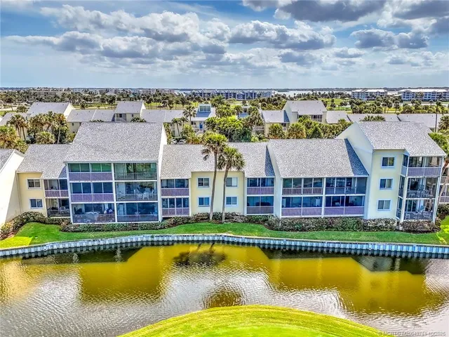 an aerial view of a house with a garden and lake view