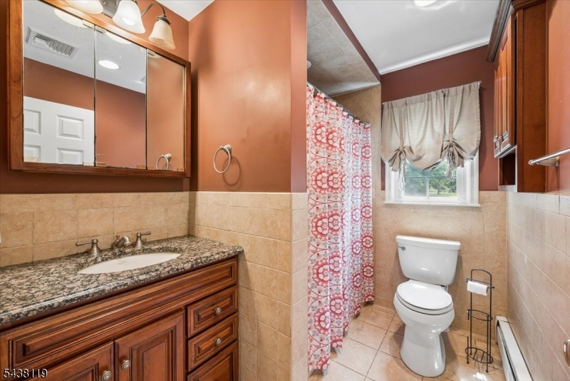 335 Drakestown Road Long Valley, NJ 07853 - Photo 22 of 34 a bathroom with a granite countertop toilet a sink a mirror a window and a shower