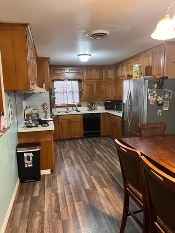 a kitchen with stainless steel appliances granite countertop sink stove refrigerator and cabinets