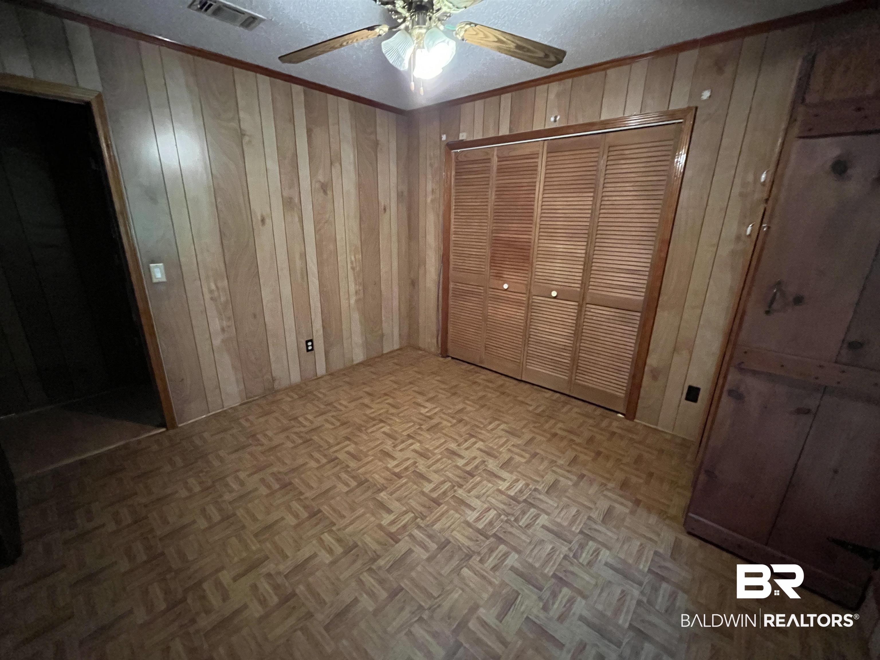 1905 Rockaway Creek Road Atmore, AL 36502 - Photo 20 of 23 Room with wood-finish paneling walls and patterned wood-finish flooring