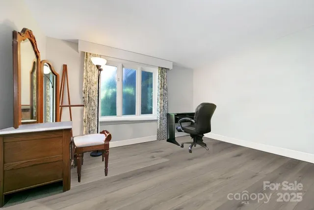 a view of a workspace with furniture and a window