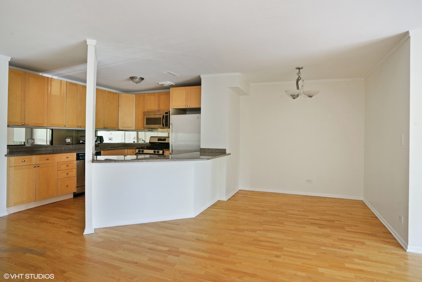 6102 North Sheridan Road, Unit 307 Chicago, IL 60660 - Photo 4 of 10 a kitchen with stainless steel appliances kitchen island granite countertop a refrigerator cabinets and wooden floor