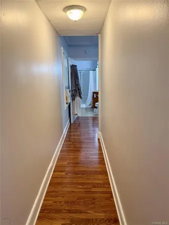 a hallway with wooden floor and staircase