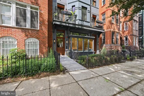 a front view of a brick building with a yard