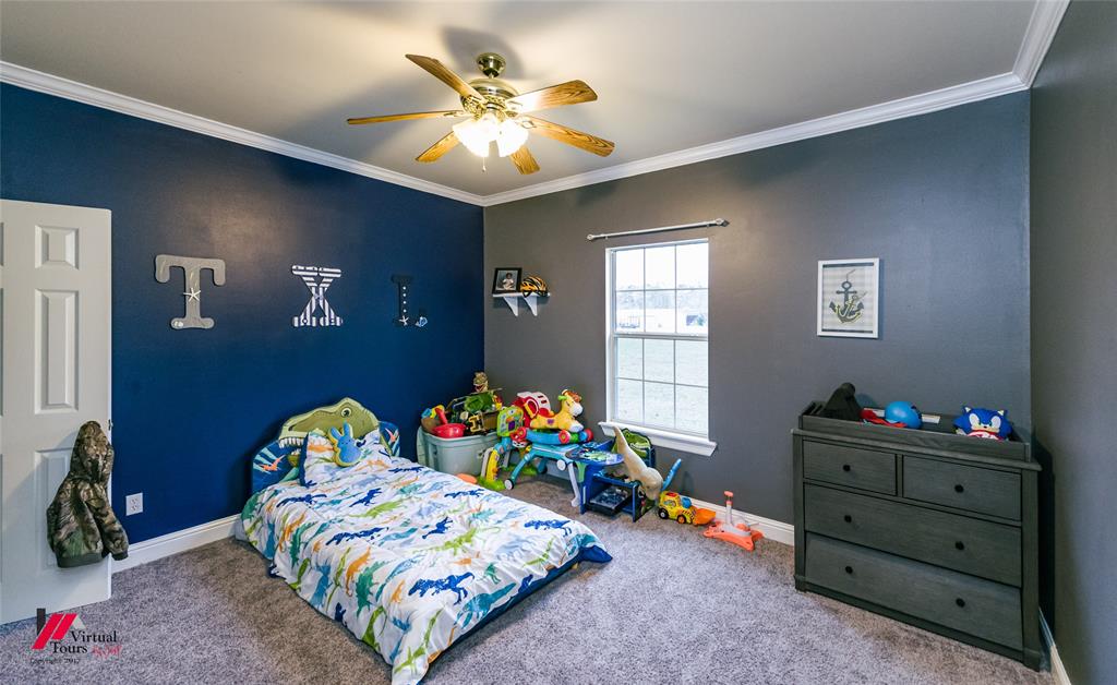 266 Stark Road Stonewall, LA 71078 - Photo 24 of 39 a bedroom with a bed and a chandelier