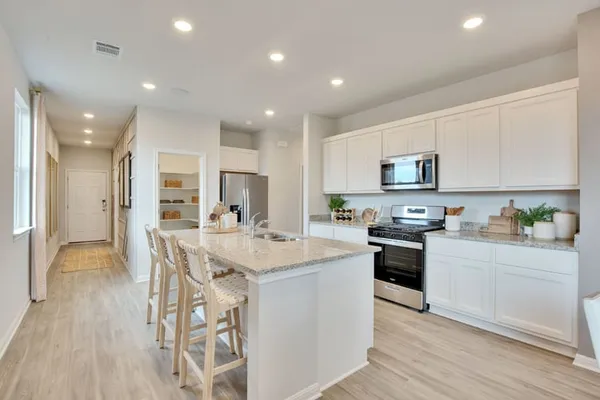 a kitchen with white cabinets stainless steel appliances and kitchen island