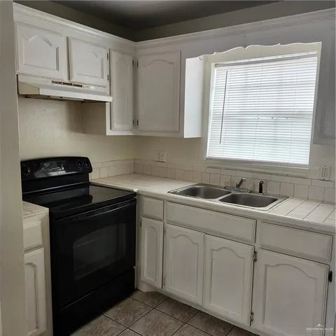 a kitchen with cabinets appliances a sink and a window