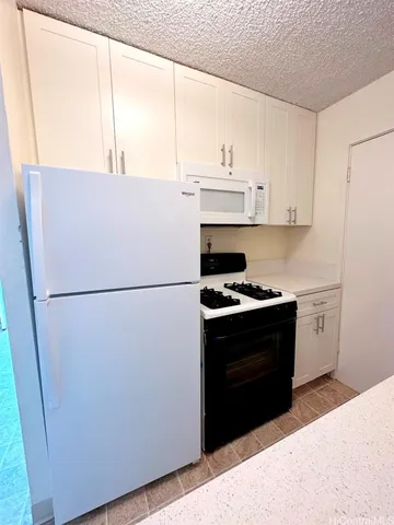 a kitchen with stainless steel appliances a refrigerator sink and white cabinets