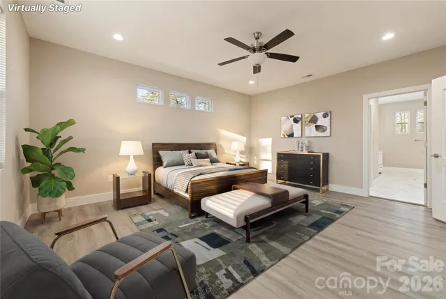 a bedroom with a bed a couch and a potted plant