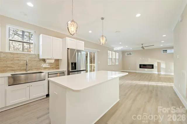 a large kitchen with kitchen island a large counter space appliances and a window