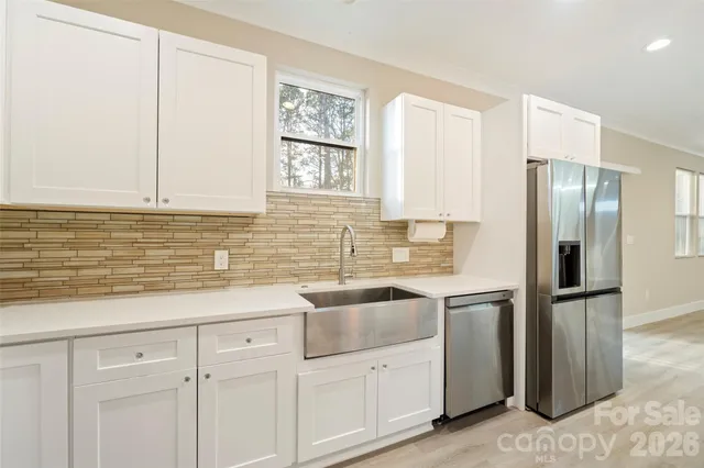 a kitchen with white cabinets and refrigerator