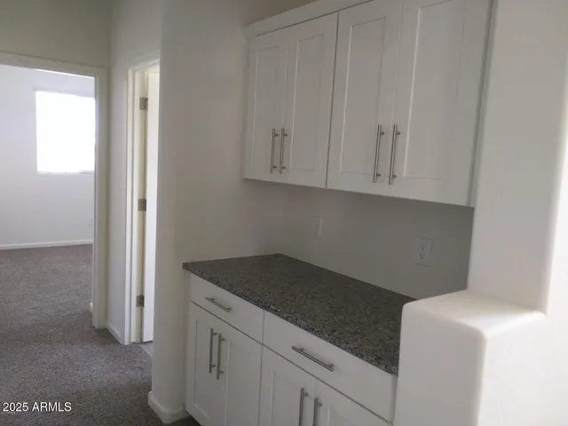 a utility room with granite countertop cabinets washer and dryer