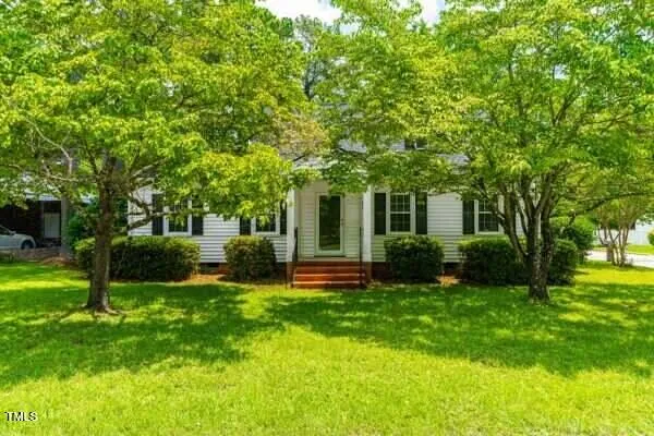 a front view of a house with a yard and trees