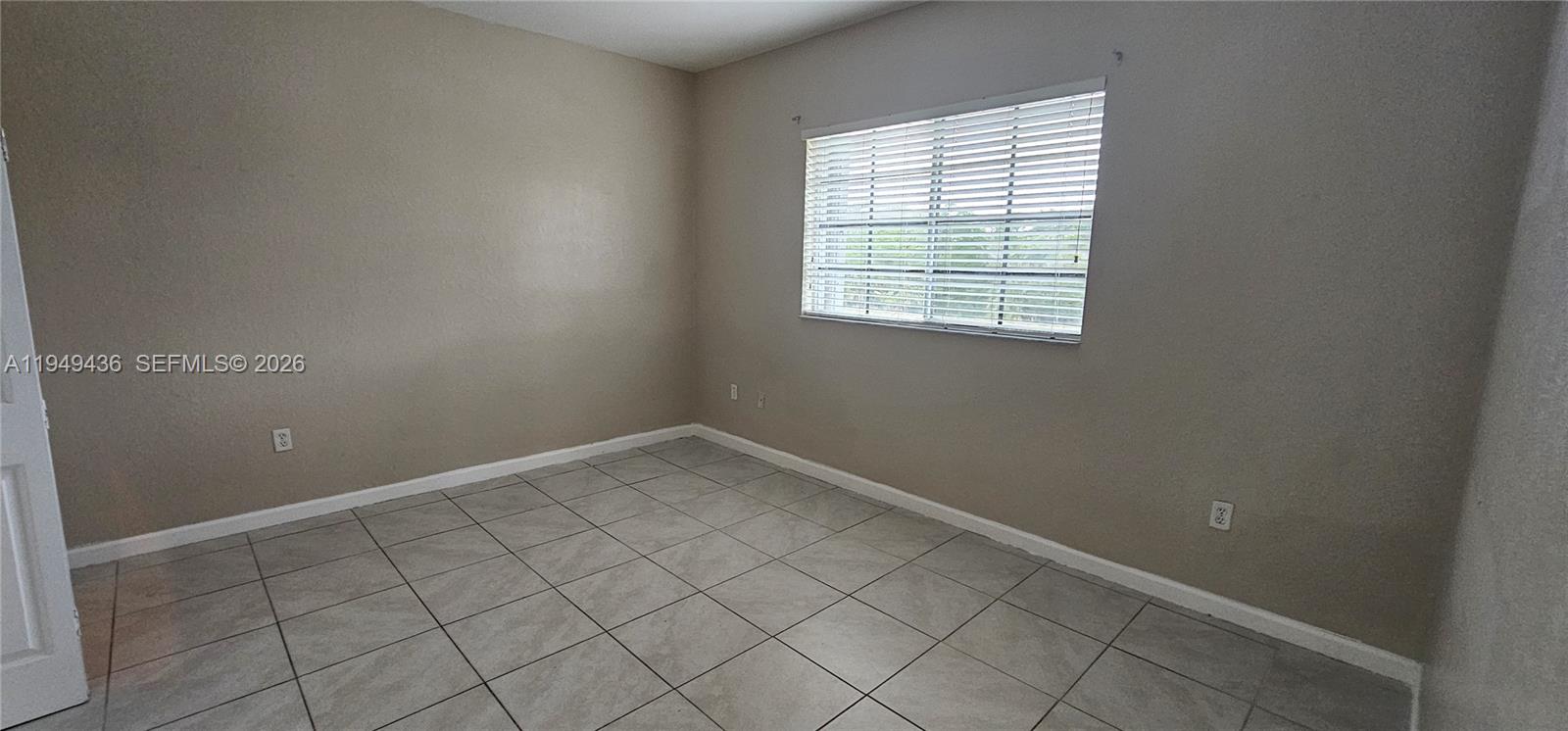 2711 Northeast 4th Street, Unit 204 Homestead, FL 33033 - Photo 8 of 13 an empty room with white walls and tiles