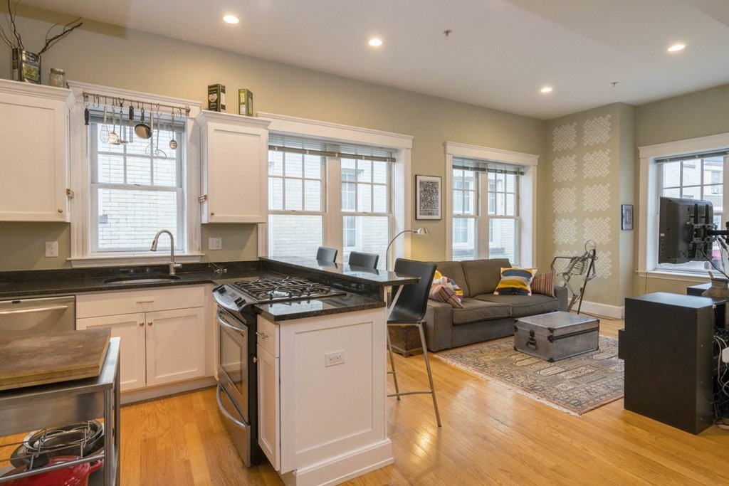 a living room with granite countertop furniture a stove a sink and a window