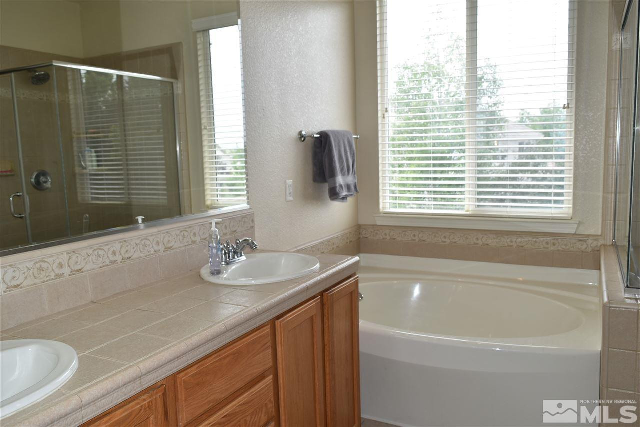 10675 Cedar Bend Court Reno, NV 89521 - Photo 12 of 22 a bathroom with a granite countertop sink and a bathtub