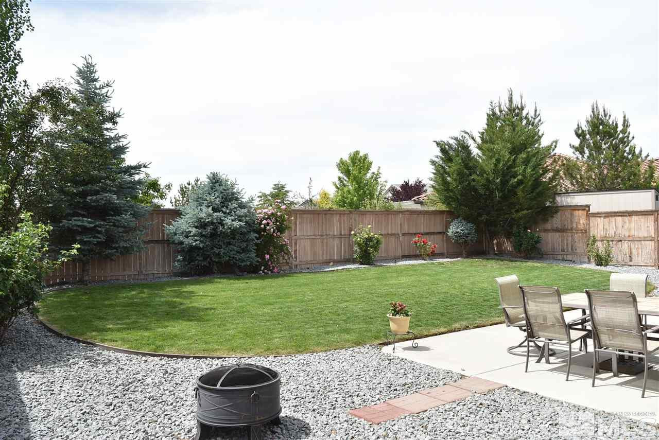 10675 Cedar Bend Court Reno, NV 89521 - Photo 3 of 22 a view of a backyard with table and chairs potted plants and wooden fence