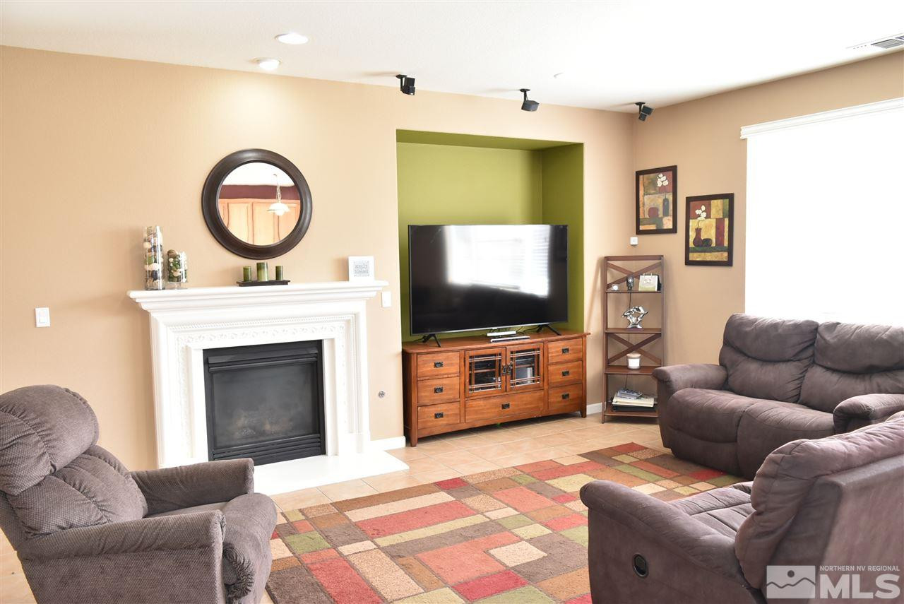 10675 Cedar Bend Court Reno, NV 89521 - Photo 8 of 22 a living room with furniture a flat screen tv and a fireplace
