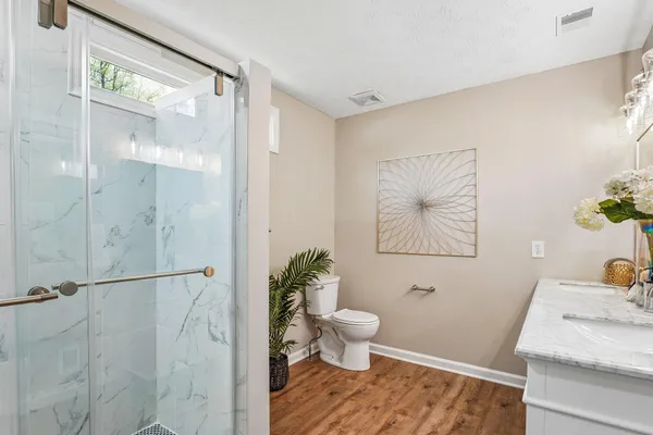a bathroom with a granite countertop sink toilet and shower