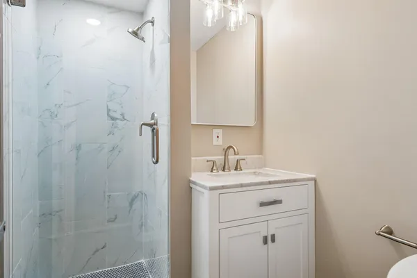 a bathroom with a sink a toilet a shower and a mirror