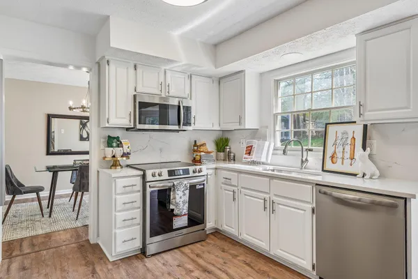 a kitchen with cabinets stainless steel appliances a sink and a stove