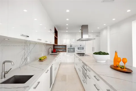 a kitchen with white cabinets and appliances