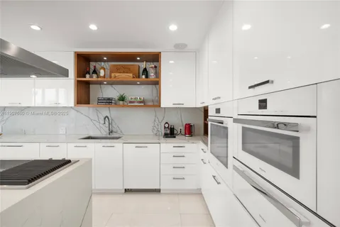 a kitchen with stainless steel appliances kitchen island granite countertop a sink and a refrigerator