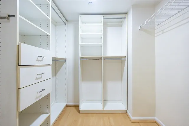 a view of walk in closet with empty racks