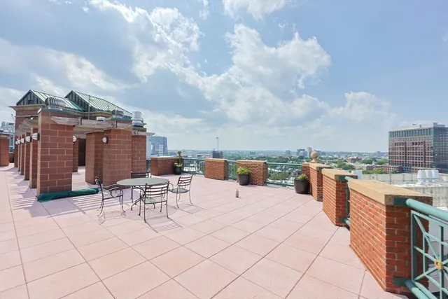 a terrace with a bench and city view