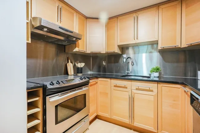 a kitchen with stainless steel appliances granite countertop a stove and a sink
