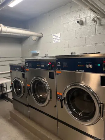 a room with kitchen island a stove a refrigerator wooden floor and cabinets