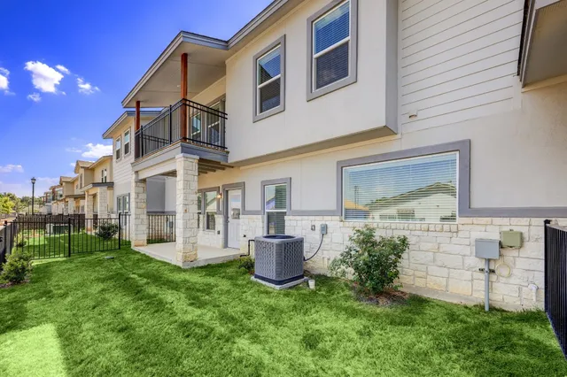 a view of a house with brick walls and a yard with a large tree