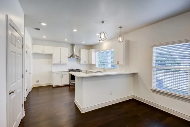 a kitchen with a sink stainless steel appliances cabinets and a window