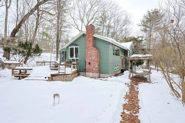 a view of a house with a yard covered in snow