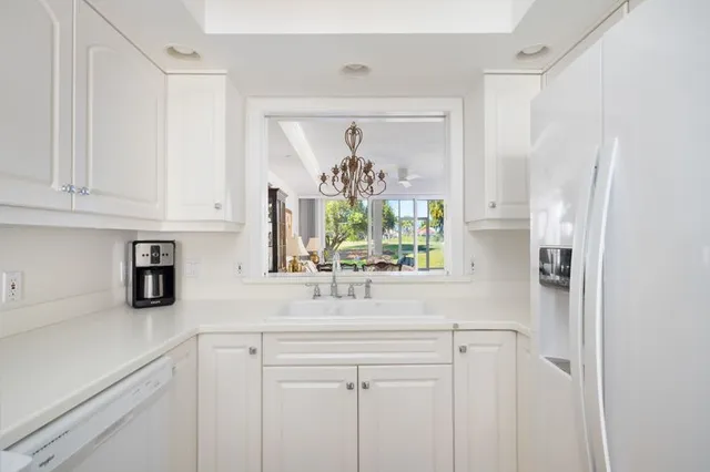 a kitchen with stainless steel appliances white cabinets and a window