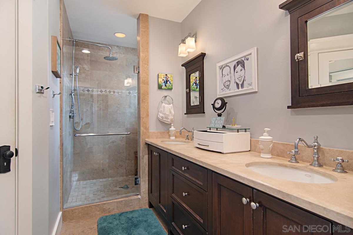 918 D Avenue Coronado, CA 92118 - Photo 23 of 41 a bathroom with a shower sink vanity granite and mirror
